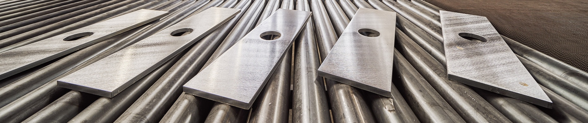 Fünf Metallbleche mit kreisförmigen Löchern.