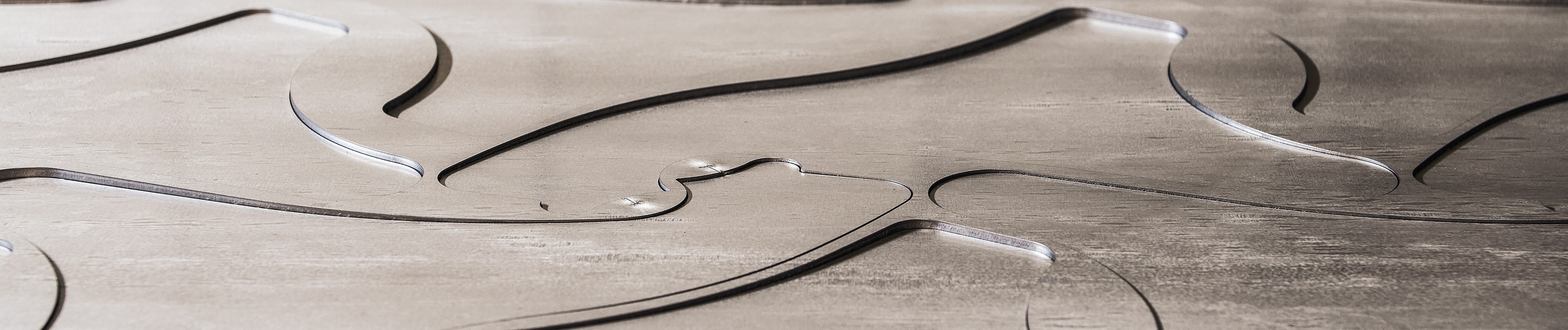 Nahaufnahme einer Metalloberfläche mit rauer Textur und runden Einkerbungen.